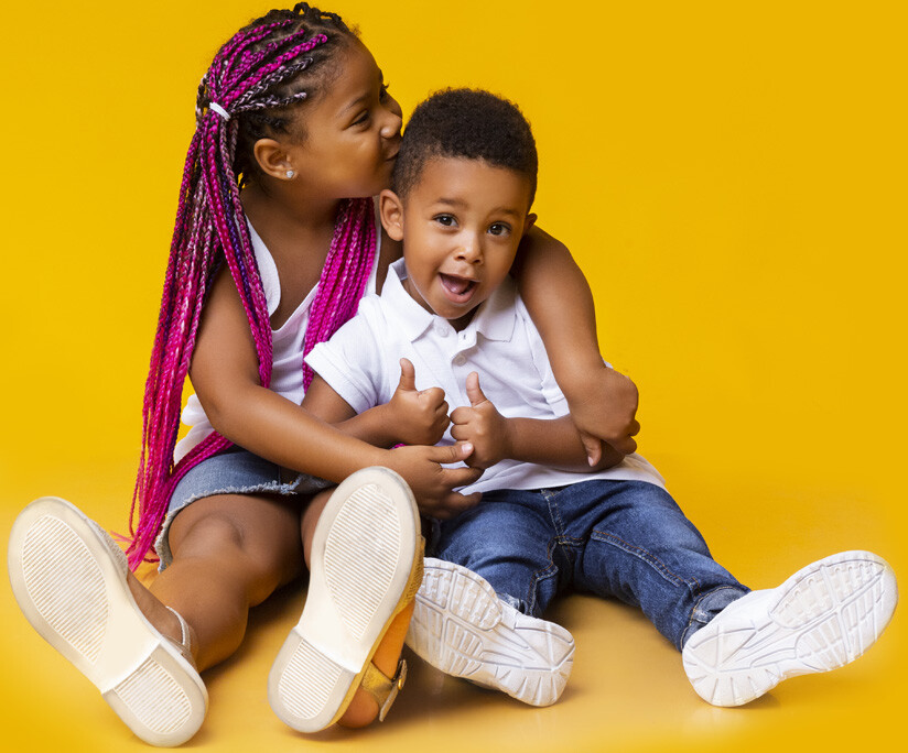 girl-pink-braids-boy-two-thumbs-up-sitting-down